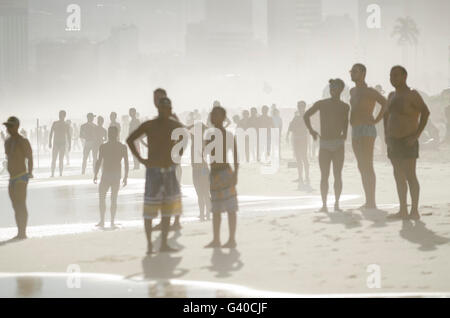 RIO DE JANEIRO - JANUARY 20, 2014: Silhouettes of beachgoers fill the shore of Ipanema at sunset on a summer afternoon. Stock Photo