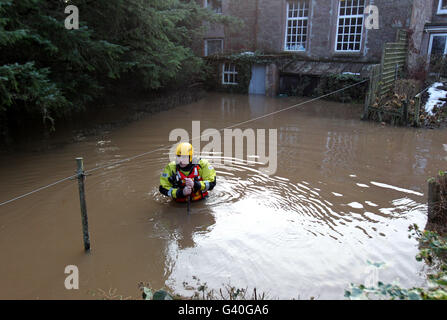 Crew manager Alan Park from Tayside Fire and Rescue checks flood waters in Back Street, Bridge of Earn, after the River Earn burst its banks due to the high volume of rain and melting snow over the last few days. Stock Photo