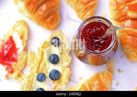 A jar of fresh raspberry jam on light rustic background, close up, in the garden, selective focus Stock Photo