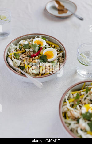 Two bowls of Crunchy Veggie Bowl with Warm Peanut Dressing is photographed from the front view. Stock Photo
