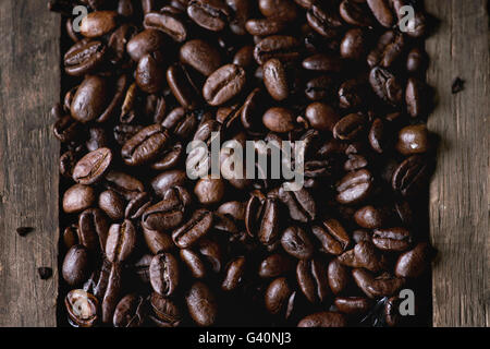 Food background with Green and brown decaf unroasted and black roasted coffee beans in old wooden box. Top view. Close up Stock Photo