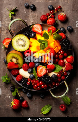 fresh summer fruits and berries on plate, above, rustic background Stock Photo