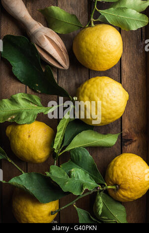 Fresh lemons with leaves in rustic wooden box. Top view Stock Photo