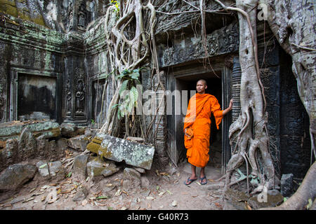 Buddhist monk in Ta Prohm doorway , Angkor Wat, Cambodia Stock Photo