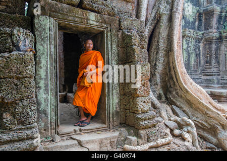 Buddhist monk in Ta Prohm doorway , Angkor Wat, Cambodia Stock Photo
