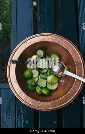 Fresh green lime in a bowl, squeezed for cocktails Stock Photo