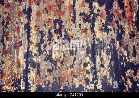 Retro toned peeling paint on metal surface, grunge background. Stock Photo