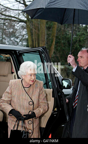 Britains Queen Elizabeth II, is sheltered from the rain on her arrival at The Sandringham Women's Institute, at West Newton Church Hall, near Sandringham, Norfolk. Stock Photo