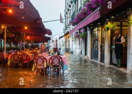 Venice, Italy. 15th June, 2016. A woman eats at the restaurant during the high water on June 15, 2016 in Venice, Italy. The high water in this period is exceptional, and it is a surprise for citizen and tourists.  Credit:  Simone Padovani /Awakening/Alamy Live News Stock Photo