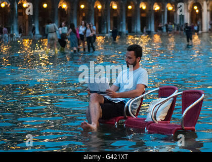 Venice, Italy. 15th June, 2016. A man draws during the high water on June 15, 2016 in Venice, Italy. The high water in this period is exceptional, and it is a surprise for citizen and tourists.  Credit:  Simone Padovani /Awakening/Alamy Live News Stock Photo