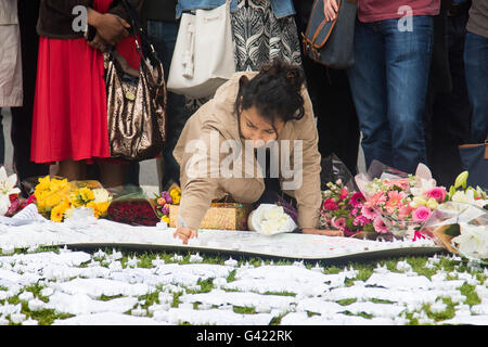 Parliament Square, Westminster, London, UK. 17th June, 2016. Following the murder of Jo Cox MP friends and members of the public lay flowers, light candles and leave notes of condolence and love in Parliament Square, opposite the House of Commons. PICTURED: A woman writes a message of condolence. Credit:  Paul Davey/Alamy Live News Stock Photo