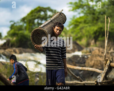 June 17, 2016 - Don Khone, Champasak, Laos - A fisherman carries a fish trap to a canoe near Khon Pa Soi Waterfalls, on the east side of Don Khon. It's the smaller of the two waterfalls in Don Khon. Fishermen have constructed an elaborate system of rope bridges over the falls they use to get to the fish traps they set. Fishermen in the area are contending with lower yields and smaller fish, threatening their way of life. The Mekong River is one of the most biodiverse and productive rivers on Earth. It is a global hotspot for freshwater fishes: over 1,000 species have been recorded there, secon Stock Photo