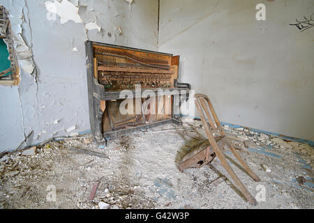 broken piano and chair in abbondoned house Lesvos Greece Stock Photo