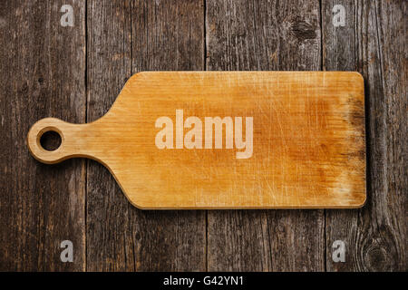 Empty vintage cutting board on dark wooden background Stock Photo