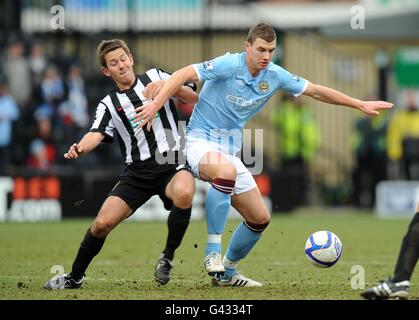 Soccer - FA Cup - Fourth Round - Notts County v Manchester City - Meadow Lane. Manchester City's Edin Dzeko (right) and Notts County's Jon Harley (left) battle for the ball Stock Photo