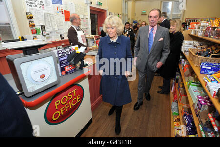 The Duchess of Cornwall takes a tour of the village shop with Chairman of the village shop Committee Guy Bagnett after visiting the Wiltshire Guild of Spinners, Weavers and Dyers in Steeple Ashton, Wiltshire. Stock Photo