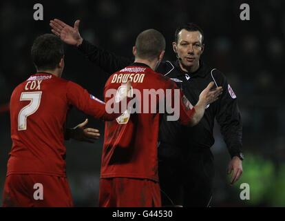 Leyton Orient's Dean Cox (left) and Stephen Dawson appeal for a decision from referee Kevin Friend (right) Stock Photo