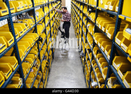 Male worker selecting parts from large distribution warehouse Stock Photo