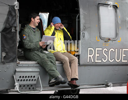 Climber Adam Potter, who survived a 1,000ft fall down Sgurr Choinnich Mor in the Nevis Range, with search and rescue winchman Petty Officer Taff Ashman looking at a map of the area where the accident happened, during a visit to Prestwick Airport where he thanked the HMS Gannet team who rescued him. Stock Photo