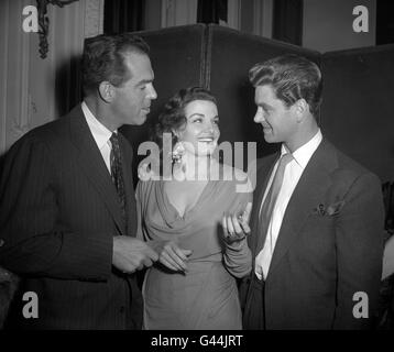 American actor Fred MacMurray (left) and American actress Jane Russell talk to British actor Anthony Steele (right), at a reception held at Londonderry House, Park Lane, London for stars attending the Royal Film Performance of 'Where No Vultures Fly'. Stock Photo