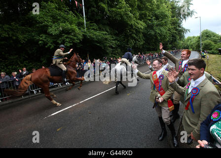 Royal Standard Bearer Rory J. Monks (standing at left of group of men) waves to riders taking part in the Selkirk Common Riding, a centuries-old tradition in the royal burgh of Selkirk in the Scottish Borders. Stock Photo