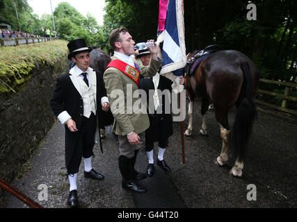 Royal Standard Bearer Rory J. Monks pauses to drink water during the Selkirk Common Riding, a centuries-old tradition in the royal burgh of Selkirk in the Scottish Borders. Stock Photo