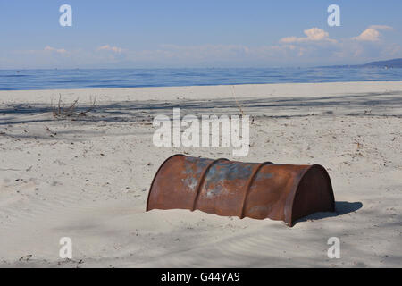 Old Rusty Oil Barrel Buried in Sand, End of Oil Age Stock Photo