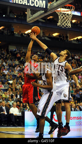 Toronto Raptors' DeMar DeRozan (left) shots over New Jerseys Nets' Travis Outlaw (centre) and New Jerseys Nets' Brook Lopez during the NBA match at the o2 Arena, London. Stock Photo