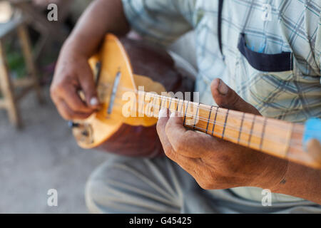 Close up shot of a man playing a Tatar instrument called 'baglama'. Stock Photo