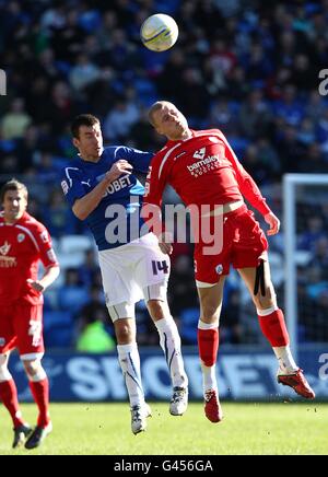 Soccer - npower Football League Championship - Cardiff City v Barnsley - Cardiff City Stadium. Cardiff City's Paul Quinn (left) and Barnsley's Jay McEveley (right) battle for the ball in the air Stock Photo