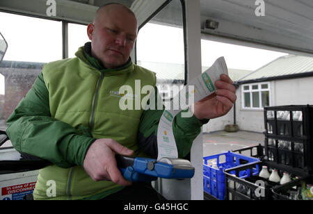 Dairy Crest milkman Tony Stevens prints off part of his round book as he delivers milk to a school in Greater Manchester. Stock Photo