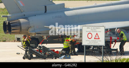 Ground crew work on an RAF Typhoon jet fighter at the Italian Airforce base of Gioia del Colle near Bari in southern Italy from where the RAF are stationed to patrol the no-fly-zone over Libya. Stock Photo