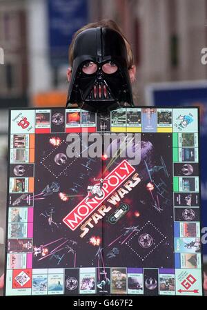 Star Wars character 'Darth Vader' holds up the limited edition version of the popular board game Monopoly. In its first revamp in 62 years, the board game replaces the familiar hat, dog, iron, boot, car and ship playing pieces with the Rebel Alliance's Luke Skywalker, Princess Leia, Han Solo, R2-D2, and Chewbacca, and baddies Darth Vader, Boba Fett and a Stormtrooper. The game was unveiled at today's (Mon) British International Toy and Hobby Fair at Olympia, London.  See PA story CONSUMER Monopoly. Photo by Sean Dempsey. Stock Photo