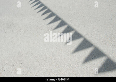 Fabric bunting shadows on a road in the cotswolds. UK Stock Photo