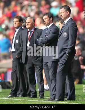 Wales manager Gary Speed (second right) with his assistant Raymond Verheijen (right) and England manager Fabio Capello (left) on the touchline prior to kick-off. Stock Photo