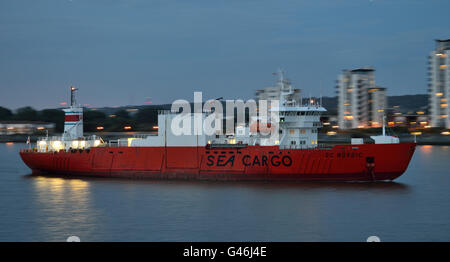 Palletized cargo carrier SC Nordic arrives on the river Thames in London after dark to collect a cargo of exports Stock Photo