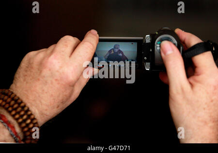 Tibet's spiritual leader, the Dalai Lama,in the Citywest Hotel Dublin seen on the screen of a video camera. PRESS ASSOCIATION Photo. Picture date: Wednesday April 13, 2011. The exiled Nobel Peace laureate begins his first trip to Ireland in 20 years with a sold-out event attended by an estimated 2,000 people in Dublin. The 76-year-old walked hand-in-hand through Dublin's Citywest Hotel with close friend Richard Moore, who was blinded by a rubber bullet in Northern Ireland as a child. See PA story IRISH DalaiLama. Photo credit should read: Julien Behal/PA Wire Stock Photo