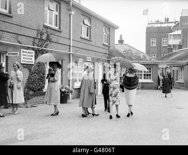 Horse Racing - Royal Ascot - Ascot Racecourse. Complete with umbrellas up, women wait outside the entrance to the Ascot enclosure Stock Photo