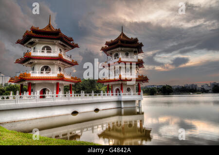 Sunset over the Twin Pagodas on a pond at Chinese Gardens, a public park in Singapore. The garden is modeled after the Chinese i Stock Photo