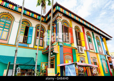 HDR rendering of a colorful building facade in Little India, Singapore, with tall high-rise apartments in the background. Stock Photo