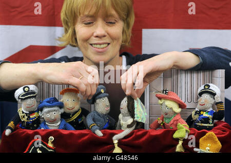 Fiona Goble adjusts knitted figures she created of attendees at the royal wedding of Prince William and Kate Middleton on display at the Earl's Court Book Fair, London. Stock Photo