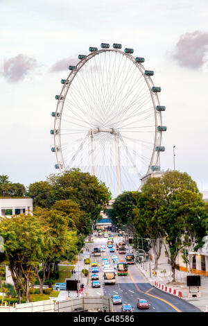 Singapore, Singapore - March 26, 2015: The Singapore Flyer ferris wheel dominates the skyline at Marina Bay. At 541 ft, it was t Stock Photo