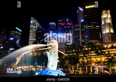 Night visitors flock to the Singapore Merlion Park at Marina Bay. The Merlion is a half-lion, half-fish sculpture. Stock Photo