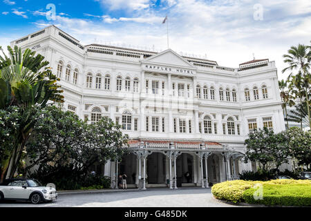 Singapore, Singapore - April 6, 2011: Guests enter the Raffles Hotel in Singapore, a famous colonial-style hotel. Stock Photo