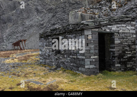 Slate buildings, abandoned workings and spoil heap, Dinorwic Slate quarries, near Llanberis, Snowdon in backgound Stock Photo