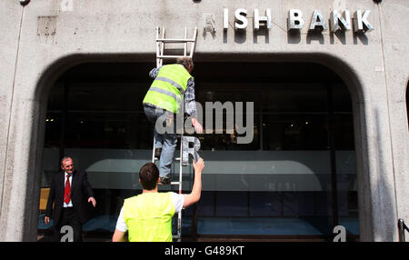 Workman remove the signage from Anglo Irish Bank headquarters at St Stephen's Green in Dublin, it was removed as the bank takes another step in winding down its loan portfolios. Stock Photo