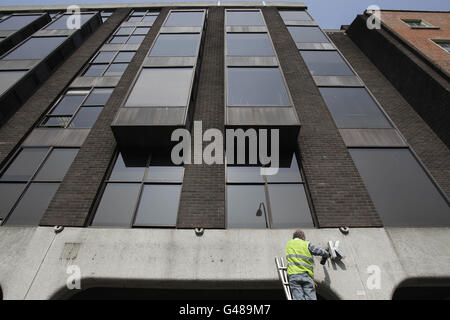 A workman removes the signage from Anglo Irish Bank headquarters at St Stephen's Green in Dublin, it was removed as the bank takes another step in winding down its loan portfolios. Stock Photo