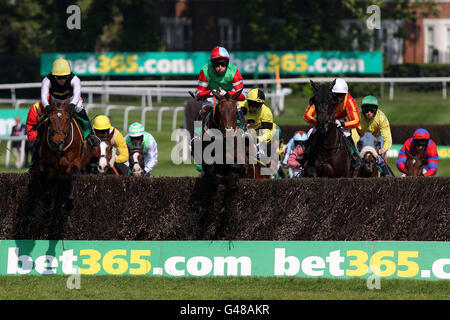 Horse Racing - bet365 Gold Cup Easter Festival - Sandown Park. Jockey Sam Twiston-Davies on Baby Run (left) and Colin Bolger on Aimigayle (centre) lead the field in the bet365 Gold Cup Chase Stock Photo