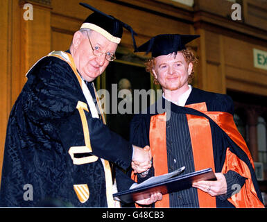 Chancellor of UMIST (The University of Manchester Institute of Science and Technology), Sir Roland Smith, presents Simply Red lead singer Mick Hucknall with his honorary degree in recognition of his contribution to life in the city of Manchester, at the University today (Weds). Pic Dave Kendall. See PA Story SHOWBIZ Hucknall. Stock Photo