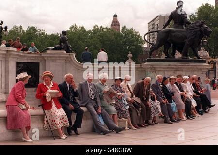 Golden Wedding couples outside Buckingham Palace this afternoon (Tuesday) before entering the grounds for a special garden party. The Queen and the Duke of Edinburgh have invited 4,000 couples, all married in 1947, to the event as part of the celebrations for their own 50th wedding anniversary. Photo by Fiona Hanson/PA. SEE PA ROYAL Anniversary stories. Stock Photo